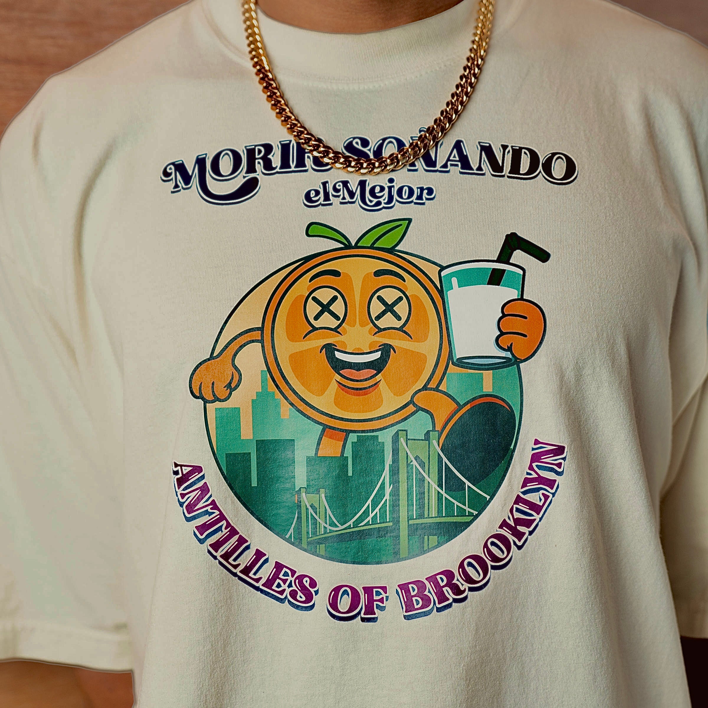 T-shirt with a colorful graphic design featuring an orange character and text on a beige background.