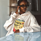 Taylor wearing a cream hoodie with a graphic design of a cafe bustelo and tips text designed by Antilles Cafe.