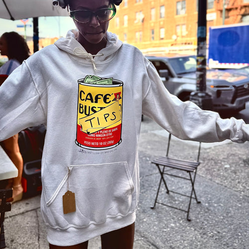 Person wearing a gray hoodie with a colorful graphic design on a city street.